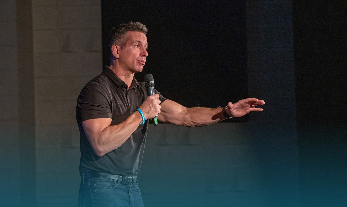 Damon West speaking on stage with a microphone